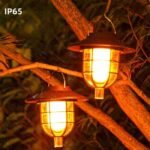 Lampes solaires effet flamme suspendues dans un arbre, éclairage chaud et scintillant, étanches IP65 pour une utilisation extérieure par tous les temps.