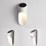 Applique murale solaire blanche avec détecteur, design moderne, fixée sur mur blanc, éclaire vers le bas.