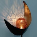 Lampe solaire décorative en forme de lune avec boule de verre éclairée, projetant une lumière féérique.