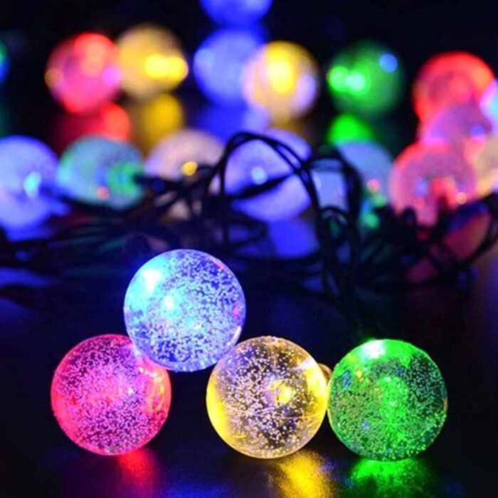 Guirlande LED boules multicolores allumées sur fond sombre, idéale pour décoration festive intérieure ou extérieure.