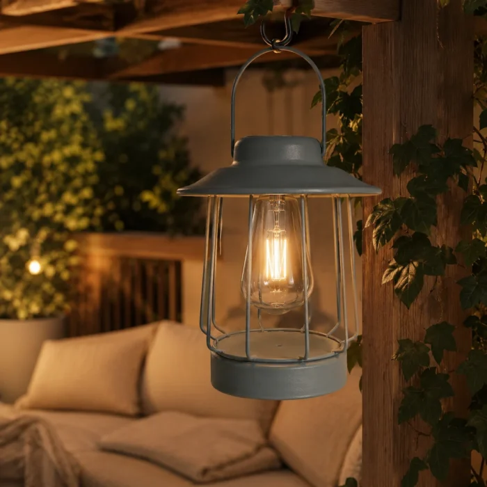 Lanterne solaire suspendue gris mat sur patio chaleureux, éclairage LED doux pour terrasse extérieure cosy.