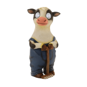Figurine décorative de vache en salopette bleue tenant un râteau, vue sur fond blanc.