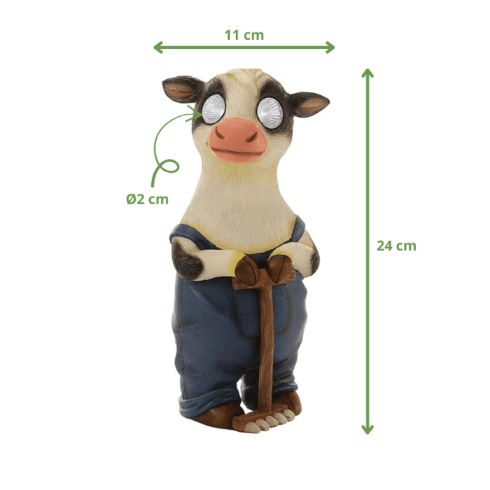 Figurine de vache en salopette bleue tenant un râteau, dimensions 24 cm de hauteur et 11 cm de largeur.
