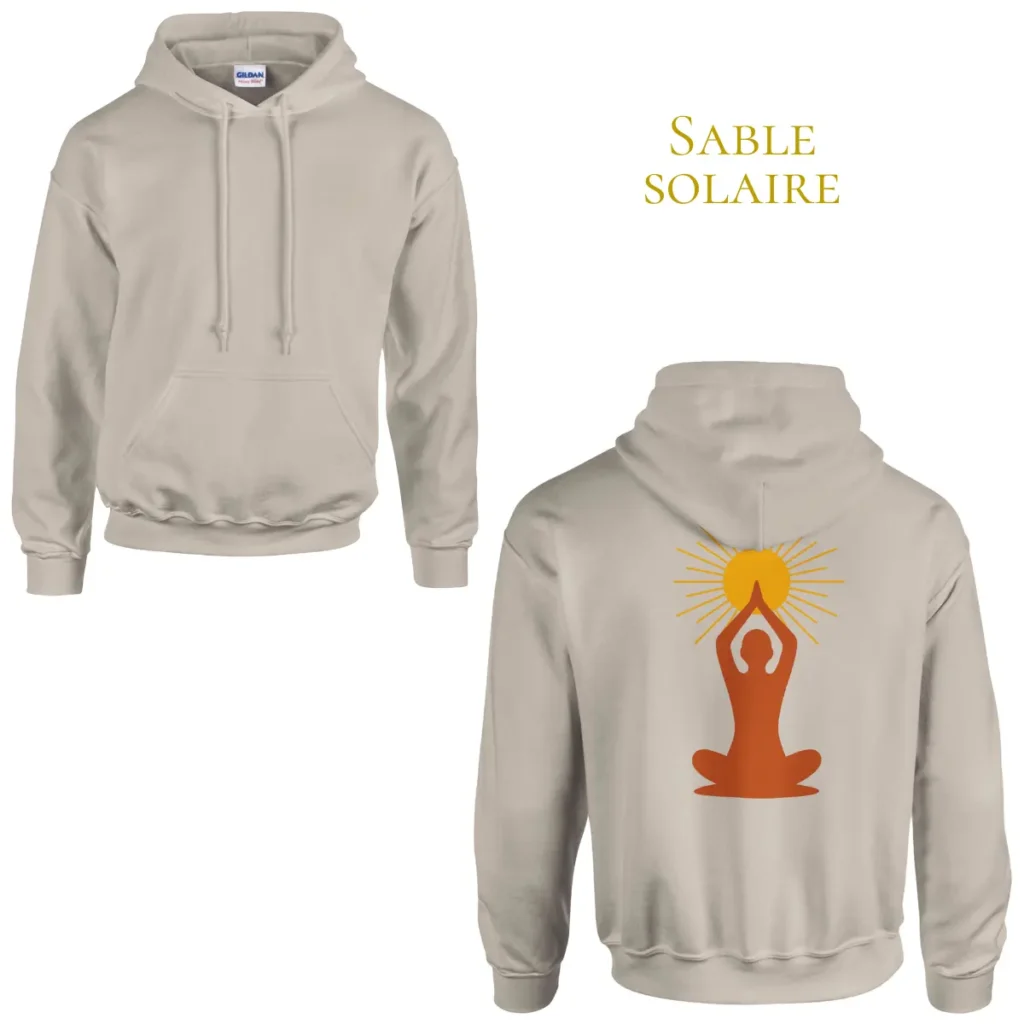 Mise en scène du hoodie Sable Solaire Solaire Universel porté au coucher du soleil dans une ambiance chaleureuse, avec symbole de méditation et soleil imprimé dans le dos.