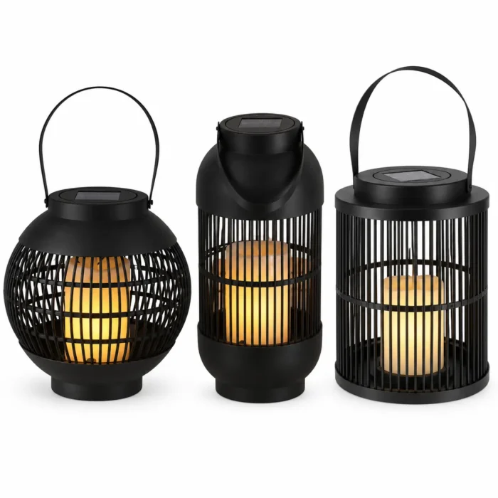 Trio de lanternes solaires LED noires avec effet bougie sur fond blanc